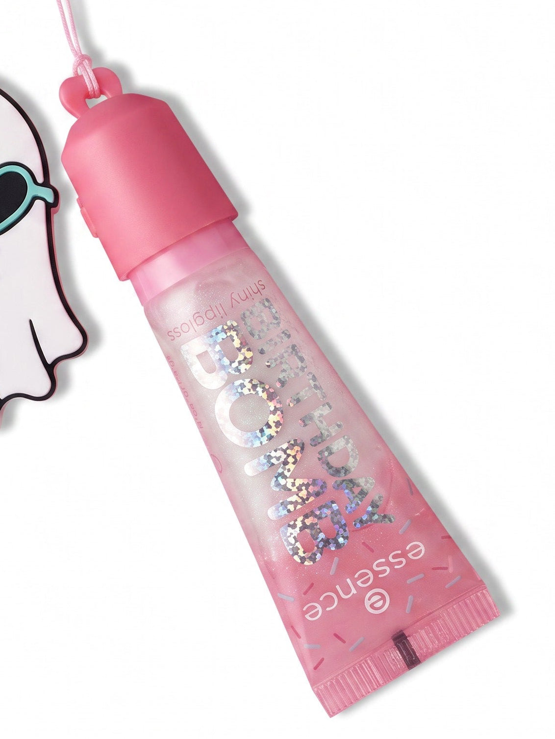 A pink lip gloss tube with glittery pink liquid and a matching pink cap, shown alongside a ghost-shaped charm with sunglasses and a teal bow on a white background.