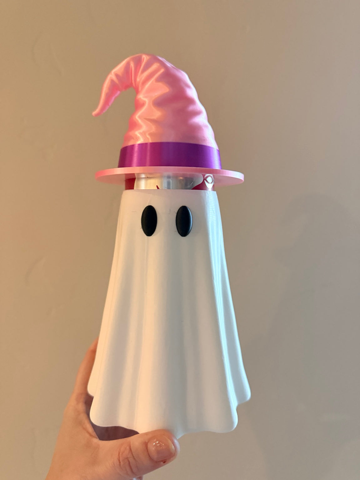 White ghost can koozie with pink and purple witch hat topper covering a canned drink