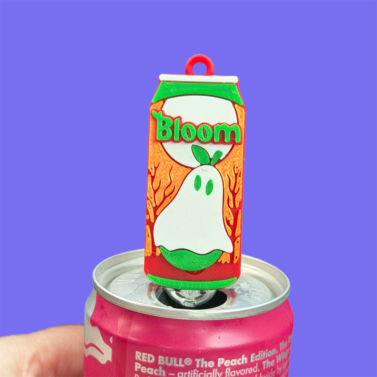Ghosted by Fall ghost-themed energy drink can tab opener displayed on a pink beverage can