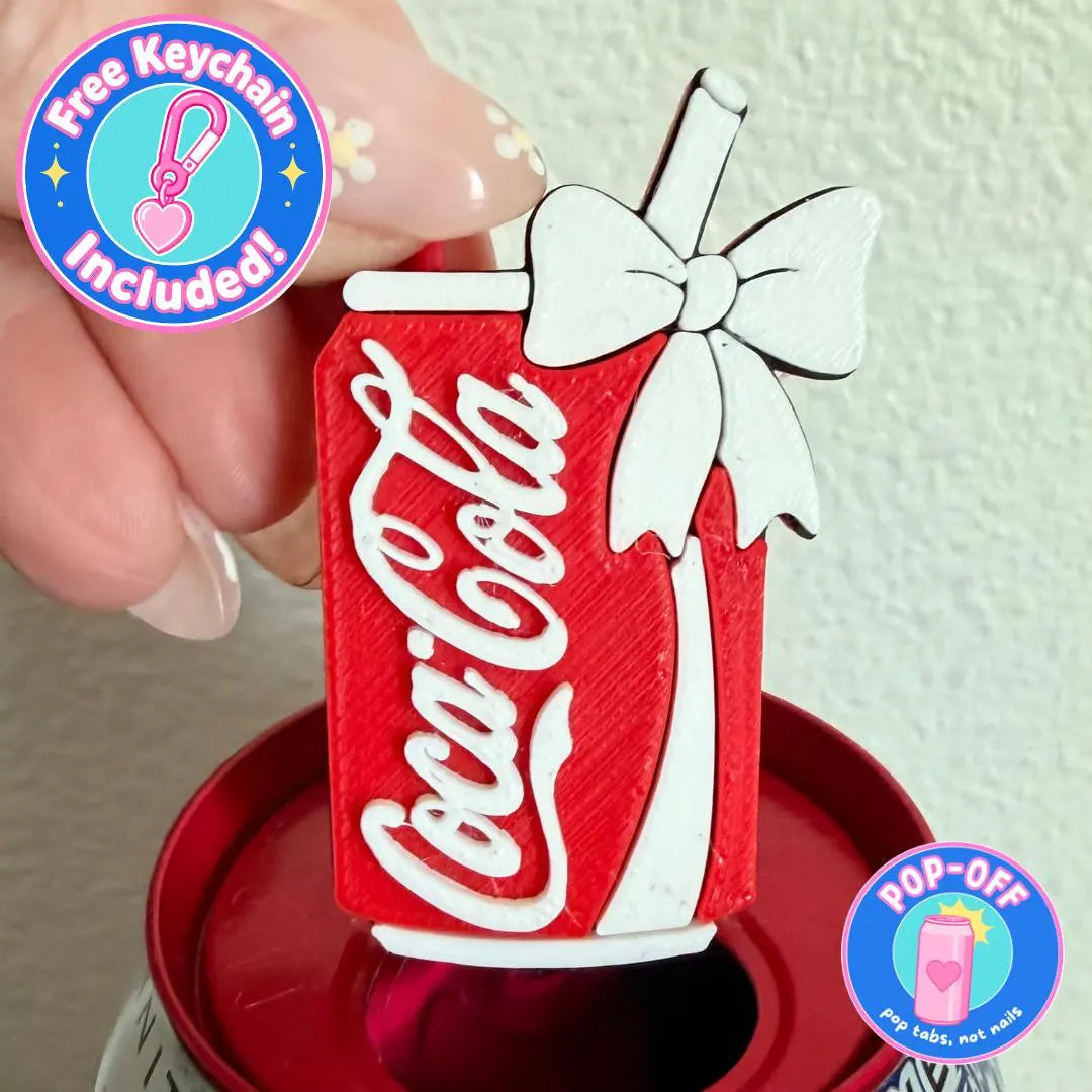 Red and white retro cola PopOff can tab opener keychain held above a drink can