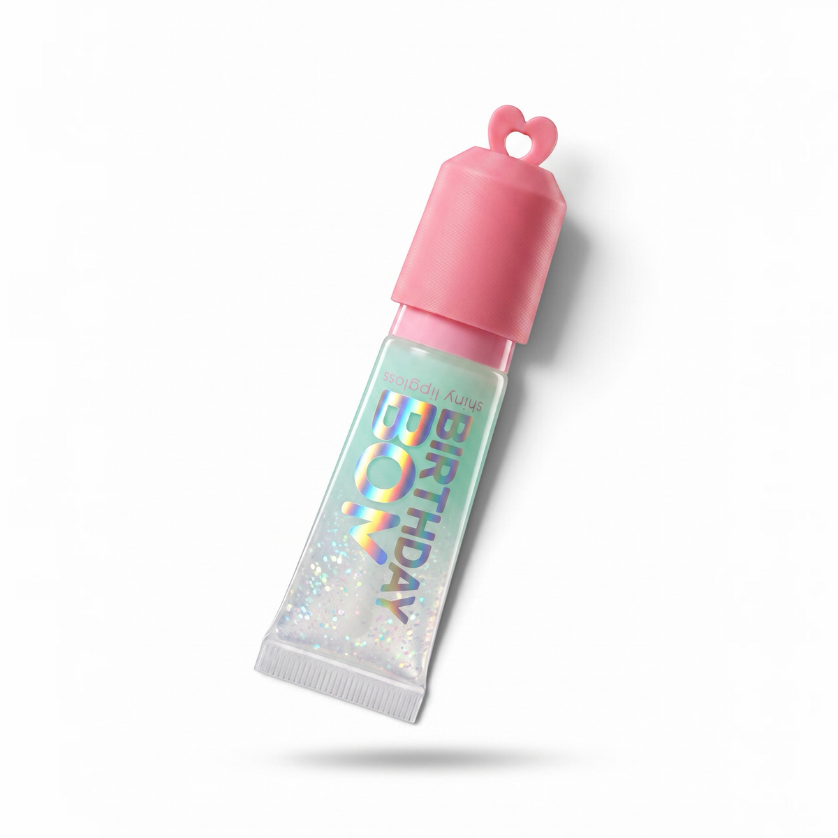 Pocket Magic Birthday Bom shiny lip gloss tube with a pink heart-shaped cap and iridescent glitter finish