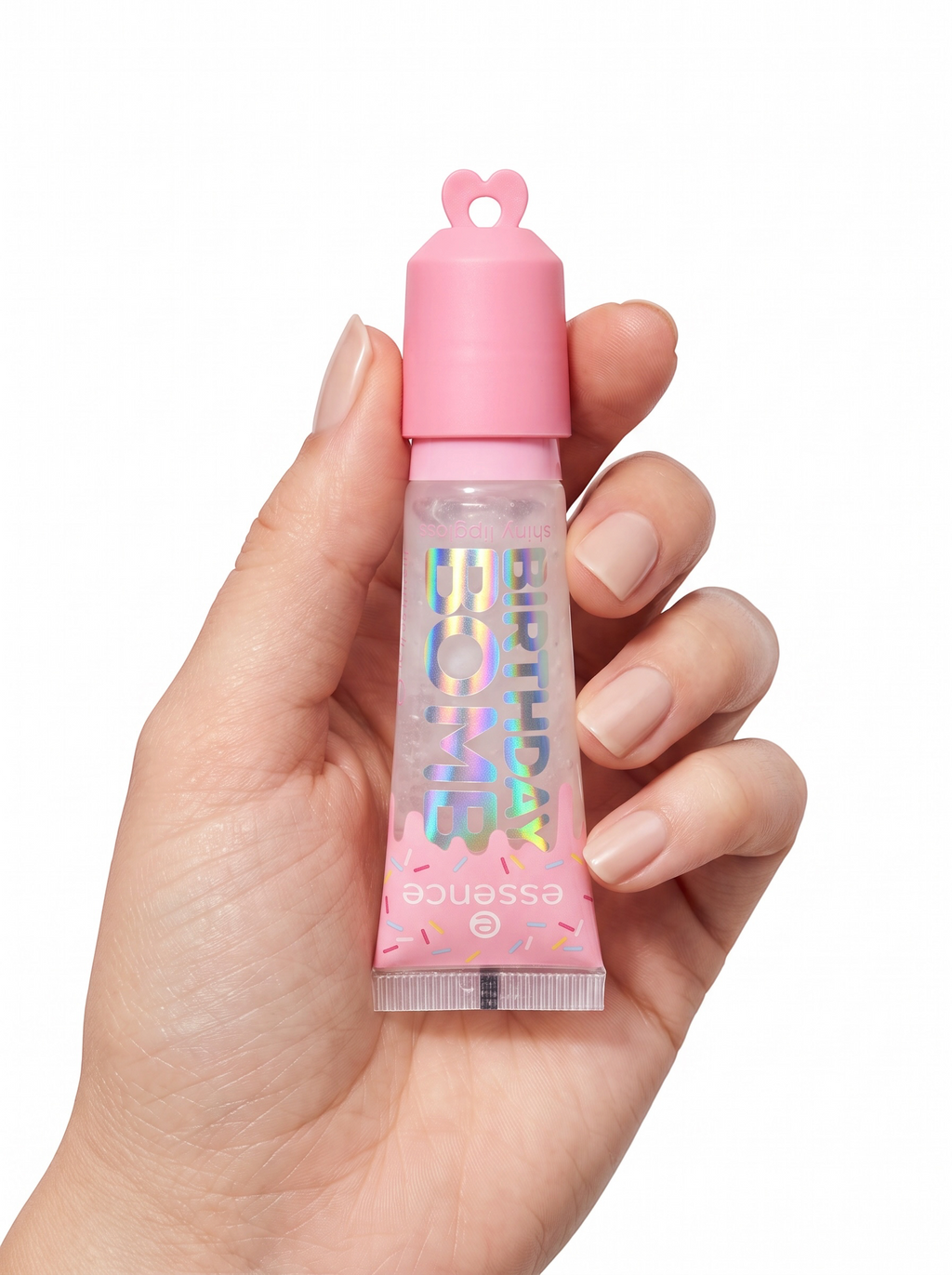 Pocket Magic essence Birthday Bomb shiny lip gloss in a pink squeeze tube held in a hand