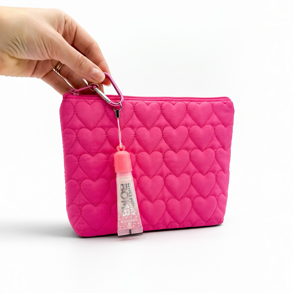 Pocket Magic pink quilted heart-patterned makeup pouch with an attached essence lip gloss keychain held by a hand